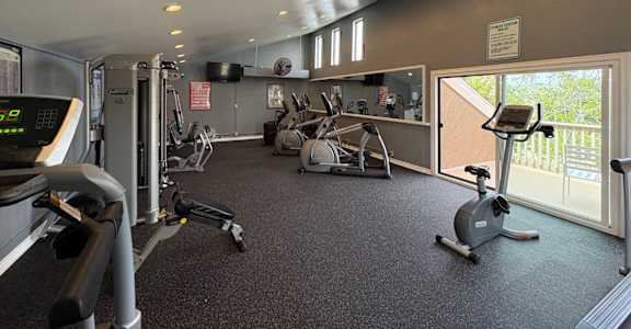 A gym with treadmills, elliptical machines, and other exercise equipment.