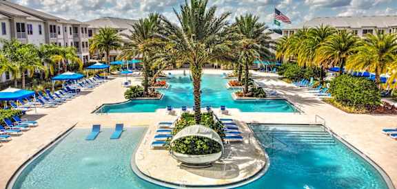 a large swimming pool with a fountain and palm trees at Palm Bay Club, Jacksonville, FL, 32258