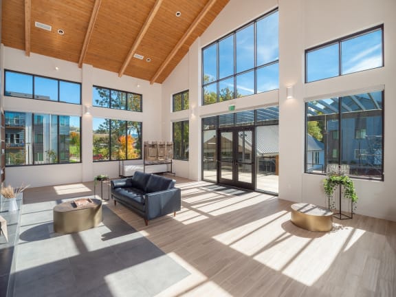 a living room with large windows and a black couch