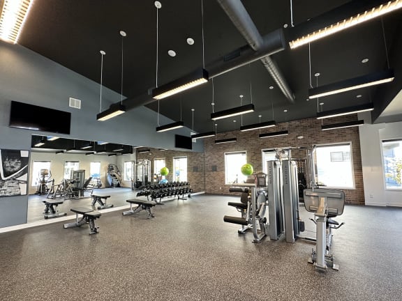 a gym with a brick wall and exercise equipment