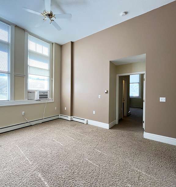 a bedroom with a bed and a ceiling fan