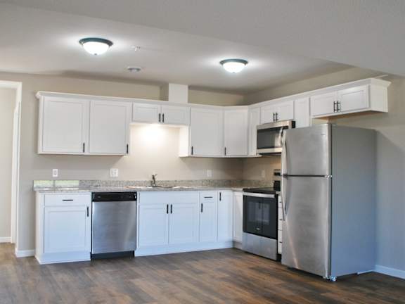 A kitchen with white cabinets and stainless steel appliances.