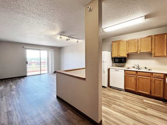 A kitchen area with wooden cabinets and a white dishwasher.
