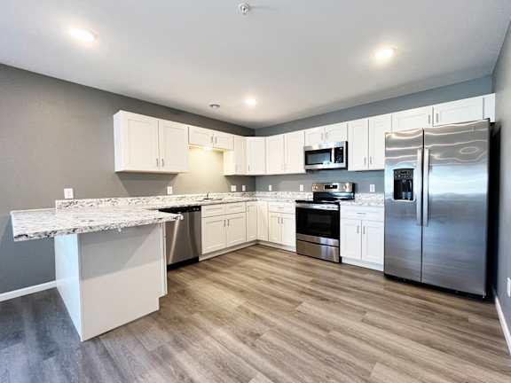 A kitchen with a marble countertop and stainless steel appliances.