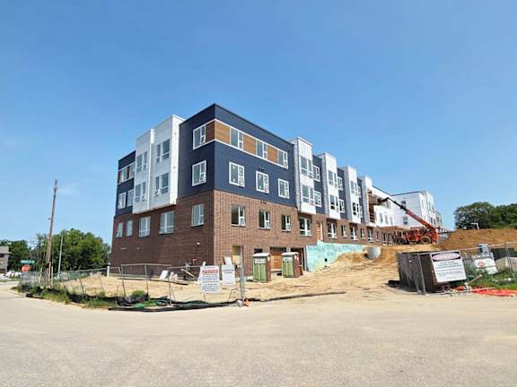 A multi-story building under construction with a clear blue sky in the background.