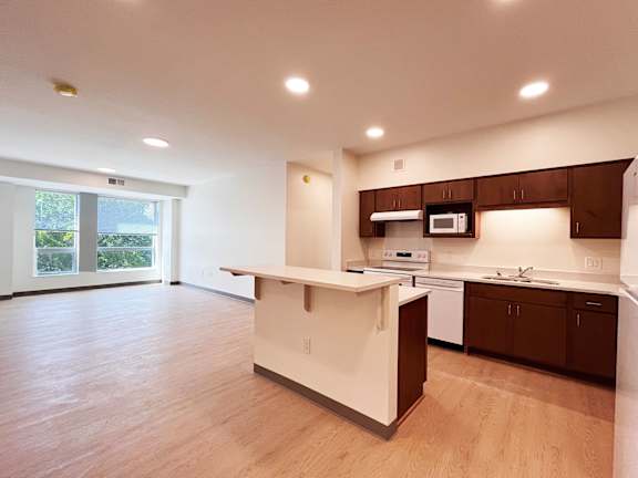 A kitchen with a white island and brown cabinets.