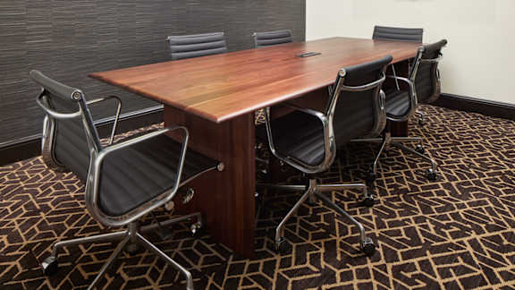 A conference room with a large table and chairs.