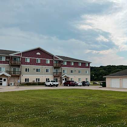 an apartment building with a green lawn in front of it
