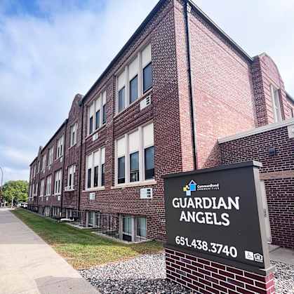 A brick building with a sign that says Guardian Angels.