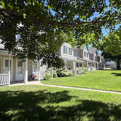 a row of houses with lawns and trees