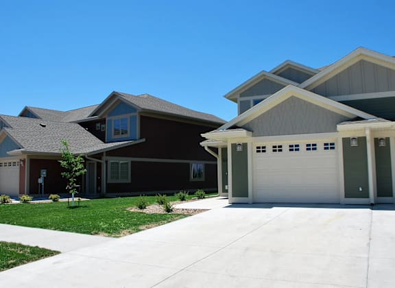 A row of houses with garages and driveways.