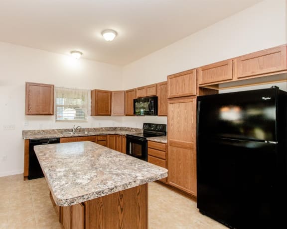 a kitchen with wooden cabinets and a granite counter top