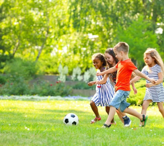 Kids Playing Soccer Together at Park
