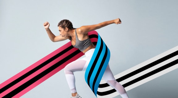 a young woman running with her leg streaked with colored lines