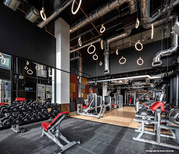 A gym with a variety of equipment including weights and cardio machines.