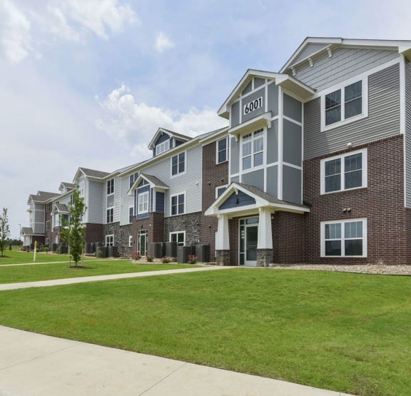 Apartment building with green grass at Dodson Pointe Apartment Homes, Rogers, AR, 72758