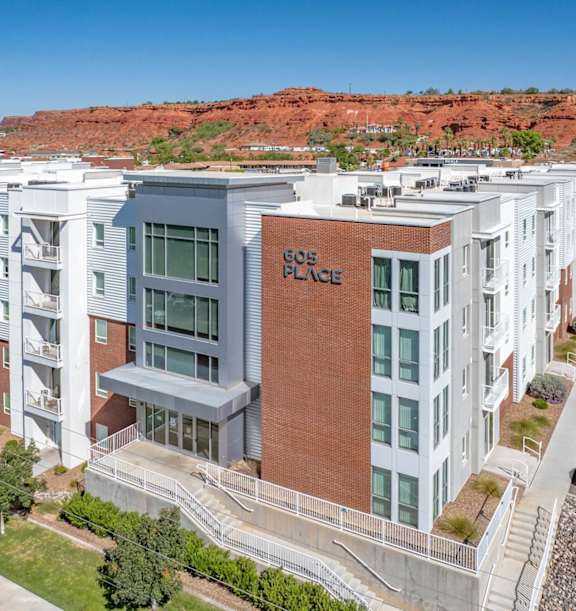 A white colored building apartment with cars at 605 Place Student Housing & Co-Living, St George, Utah