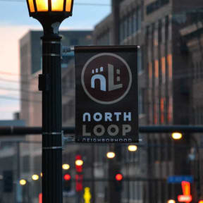 a sign for north loop on a lamp post in the city