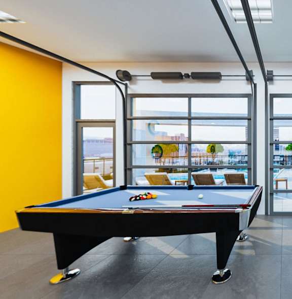 a pool table in a living room with a yellow wall and glass doors at Soll, Iowa