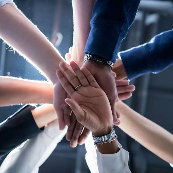 A group of people stacking their hands together.