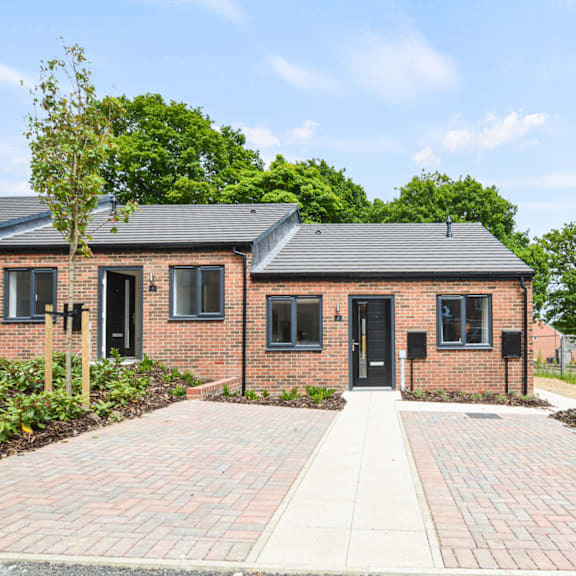 A brick house with a black door and windows.