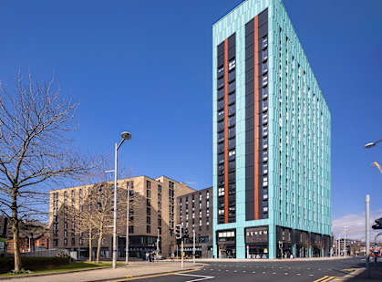 A modern glass building stands tall in the cityscape.
