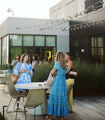 A group of women are standing around a table outside a building at Scout Living, powered by Placemakr, Atlanta, GA