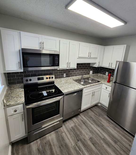 a kitchen with stainless steel appliances and white cabinets