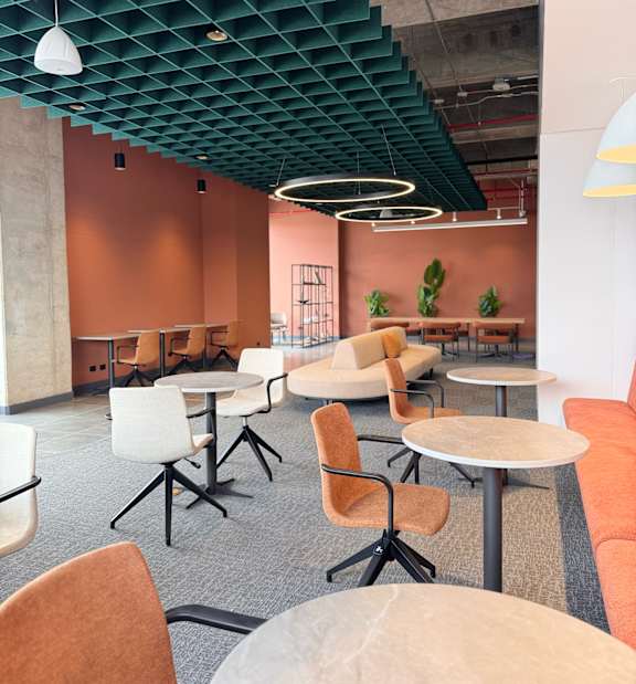 A modern office space with orange walls and white furniture.