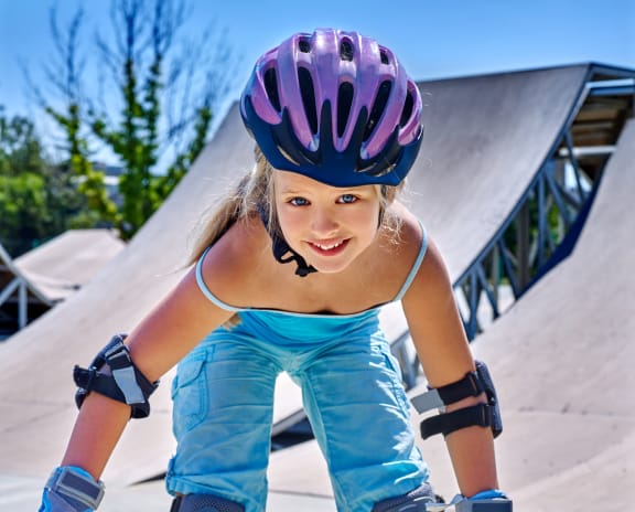a young girl on a skateboard at a skate park