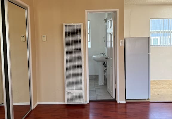 A kitchen with a stainless steel refrigerator and a wooden cabinet.