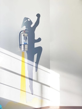 a shadow of a person holding a fire hydrant on a wall