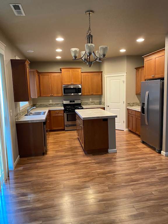 a kitchen with wood floors and wooden cabinets