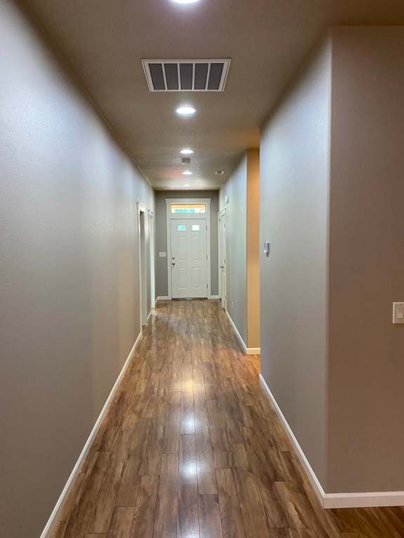 a long corridor with wood floors and grey walls