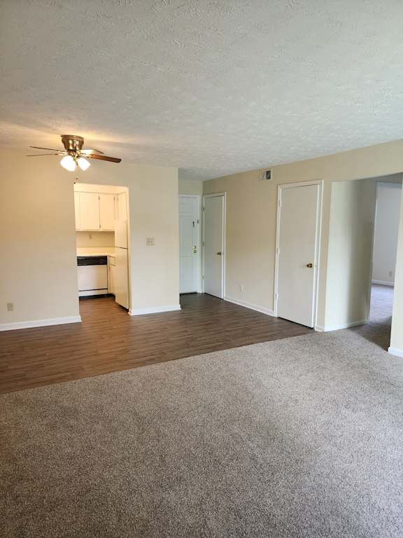 A room with a ceiling fan and carpeted floor.