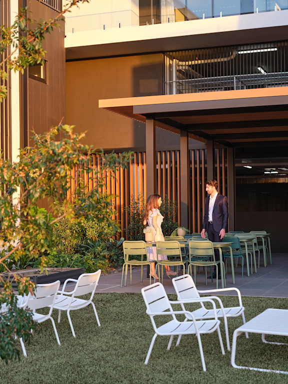 a man and a woman standing in front of tables and chairs