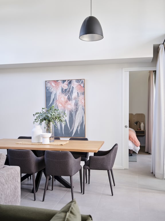 a dining room with a wooden table and chairs and a pendant light