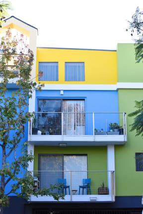 Blue/Yellow/Green  Apartment Exterior with View of Private Patio and mature Trees at Croft Plaza Apartments, West Hollywood, CA