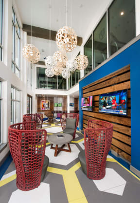 a lobby with red wicker chairs and a blue wall with large windows