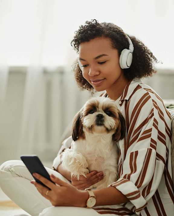 A woman is sitting on the floor with a dog and a tablet at Peach Tree Apartments, Ankeny, IA,  50021