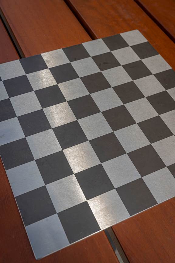 a black and white chess board on a wooden floor