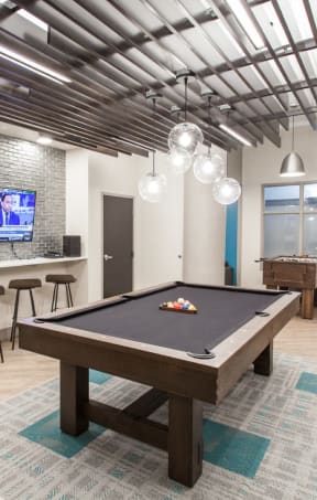 a pool table in a game room with a tv