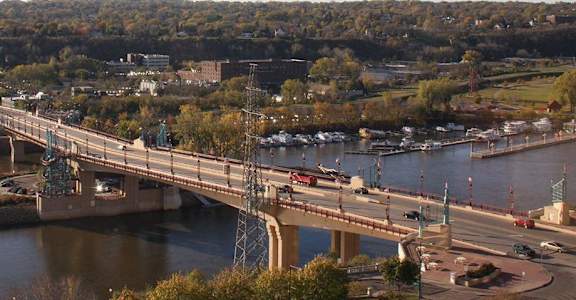 A bridge over a river with cars driving on it.