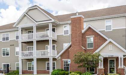 Apartment building with balconies and a car parked in front.