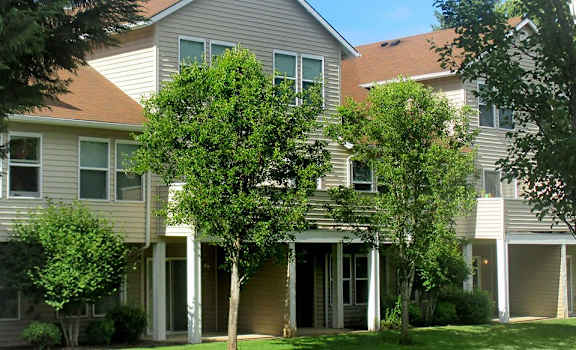 an apartment building with trees in front of it at Quail Run Apartments, Vancouver, WA