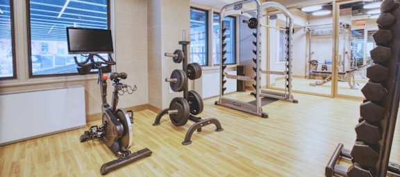 A gym with a variety of equipment including weights and a stationary bike.at 301E94, New York New York