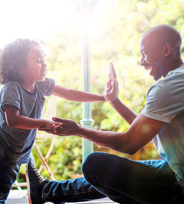 Stock photo of a dad playing with his son at Riverstone Apartments in Antioch, CA