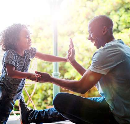 Stock photo of a dad playing with his son at Riverstone Apartments in Antioch, CA