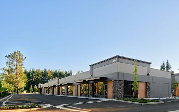 A modern building with a parking lot in front.