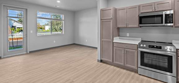 A kitchen with wooden floors and stainless steel appliances.